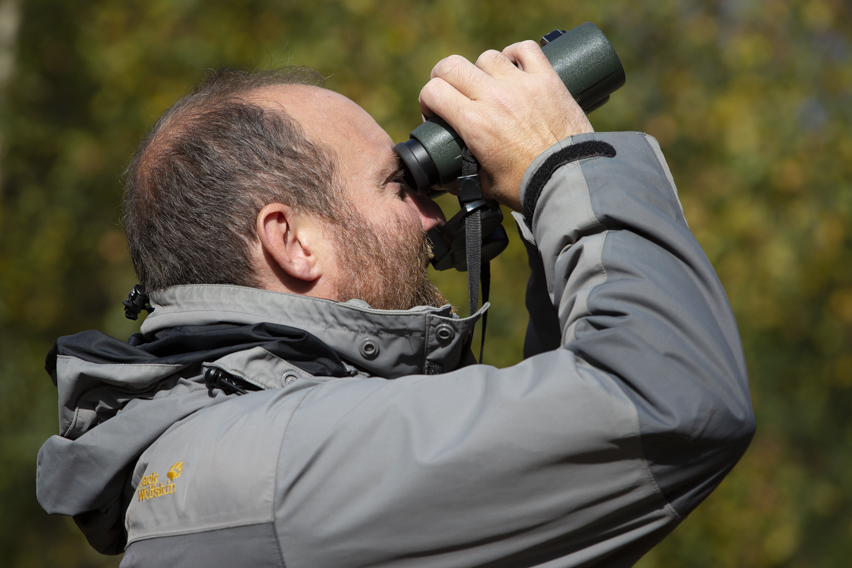 Ed Drewitt watching birds through binoculars